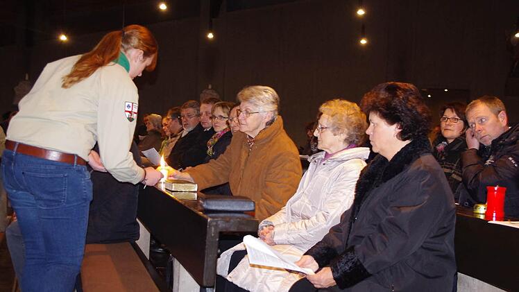 Theresa Wich gibt das Licht an die Gottesdienst-Besucher weiter.
