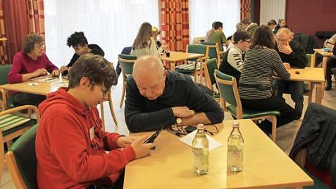 Ein Schüler erklärt einem Senior das Handy.