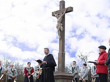 Pater Rudolf Götz OSA (Mitte) segnete das sanierte Feldkreuz am Wanderweg von Münnerstadt nach Fridritt. Rechts der stellvertretende Vorsitzende des Rhönklub-Zweigvereins Münnerstadt, Rainer Kirch, und Bürgermeister Helmut Blank. Im Hintergrund Mitglieder der Musikkapelle Fridritt, die die Feier musikalisch umrahmten.  Foto: Dieter Britz