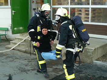 Mit schwerem Atemschutz ausgerüstet bergen Feuerwehrleute "verletzte" Recaro-Mitarbeiter aus dem Gebäude. Fotos: Klaus-Peter Wulf