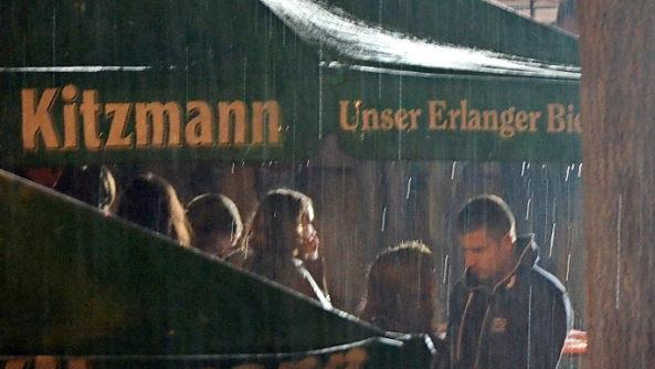 Während sich die einen unterstellen, suchen andere schon den Heimweg: Wolkenbruch am Freitag.