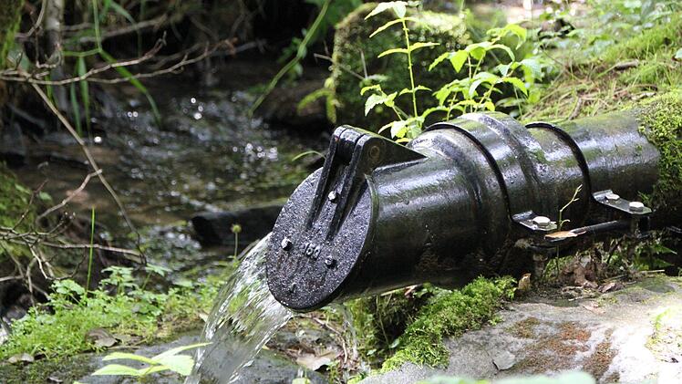Am Überlauf holen sich etliche Einheimische das unbehandelte Wasser. Sie schwören auf dessen Heilkraft. Foto: Ulrike Müller