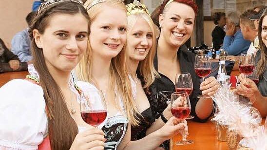 Auf dem Neuseser Weinfest wimmelte es am Freitagabend nur so von schönen Weinhoheiten. Gemeinsam stießen sie auf einen schönen Sommerabend an. Foto: Alfred Molitor