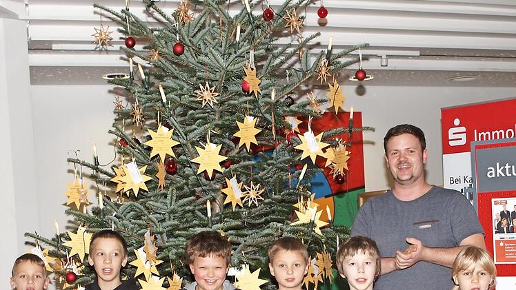 Mit einer kleinen Feier im Foyer der Sparkasse, die Jugendliche vom Hort St. Martin mit einigen Liedern umrahmten, wurde die Hilfsaktion "Weihnachten für andere" unter dem Motto "Pflücken Sie einen Wunschstern vom Weihnachtsbaum" eröffnet. Foto: Alfred Thieret