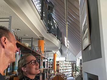 Wagenhäuser vor Wagenhäuser mit Betrachterin - vor einem Werk der Hallstadter Artothek, das in der Stadtbücherei hängt. Foto: Schreiber