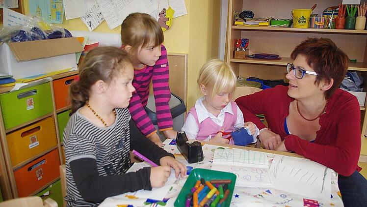 Madlen, Katharina und Victoria (von links) malen gern. Mit im Bild ist Kita-Leiterin Elke Reif-Beck. Fotos: Heike Schülein