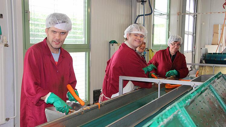 Mitarbeiter am Karottenschälband. Fotos: Sabine Paulus