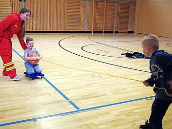 Die Jungen und Mädchen "retten" ihre Klassenkameraden mit einem zugeworfenen Rettungsball.