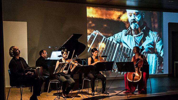 Faszinierende Kombination: Gemeinsam mit dem Bandoneon-Virtuosen Kostas Raptis musizierte das Flex Ensemble in Coburg. Zur Musik präsentierte Tosh Leykum Video-Sequenzen.Foto: Jochen Berger