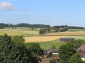 Die bereits bestehenden Windräder bei Rugendorf bekommen höchstwahrscheinlich Zuwachs. Drei weitere Mühlen - doppelt so hoch wie die jetzigen - sollen auf dem Höhenzug in Richtung Seibelsdorf entstehen. Im Bildvordergrund ist das Untere Dorf zu sehen, bei den Häusern vor den beiden Windkraftanlagen handelt es sich um Kübelhof. Foto: Sandra Zeitler