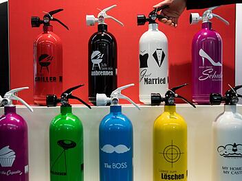 Feuerlöscher sollen auch gut aussehen - hier sind welche mit unterschiedlichen Aufdrucken während der Brandschutzmesse "FeuerTrutz" in Nürnberg zu sehen.  Foto: Daniel Karmann/dpa