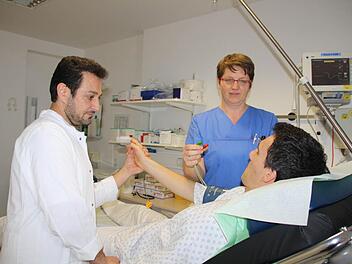 Wenn die Patienten nicht aggressiv sind, kommt als erster Schritt in der Notaufnahme des St. Elisabeth-Krankenhauses immer eine eingehende Untersuchung. In dieser nachgestellten Szene schließen Arzt Semko Aram (links) und Krankenschwester Olga Jakel die Geräte zur Überwachung an. Foto: Ralf Ruppert