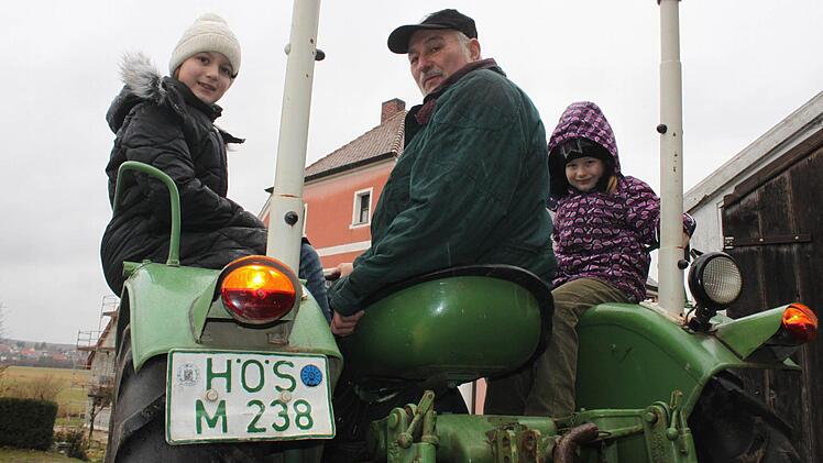 Rudolf Schwandner aus dem Höchstadter Ortsteil Greiendorf fährt noch einen Bulldog, der ein HÖS-Kennzeichen hat. Auch die Enkelinnen Vanessa (links) und Christina dürfen mal Probe sitzen. Foto: Andreas Dorsch