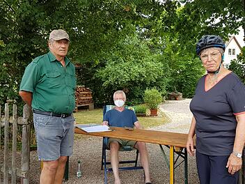 Christian Schmeußer sammelt in der Hofeinfahrt Unterschriften gegen die Filialschließung der VR Bank. Helene Heinkelmann und Max Hermannsdörfer unterstützen den Protest.