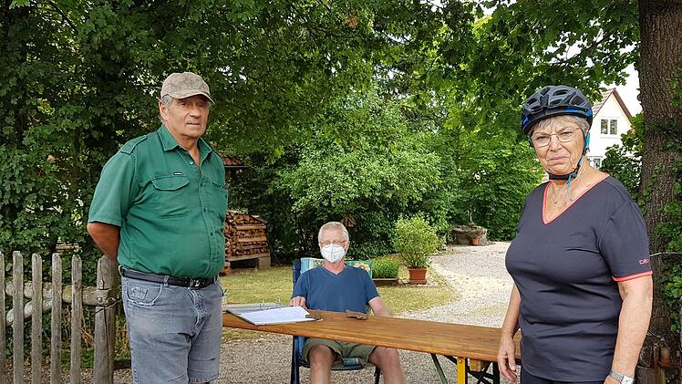 Christian Schmeußer sammelt in der Hofeinfahrt Unterschriften gegen die Filialschließung der VR Bank. Helene Heinkelmann und Max Hermannsdörfer unterstützen den Protest.