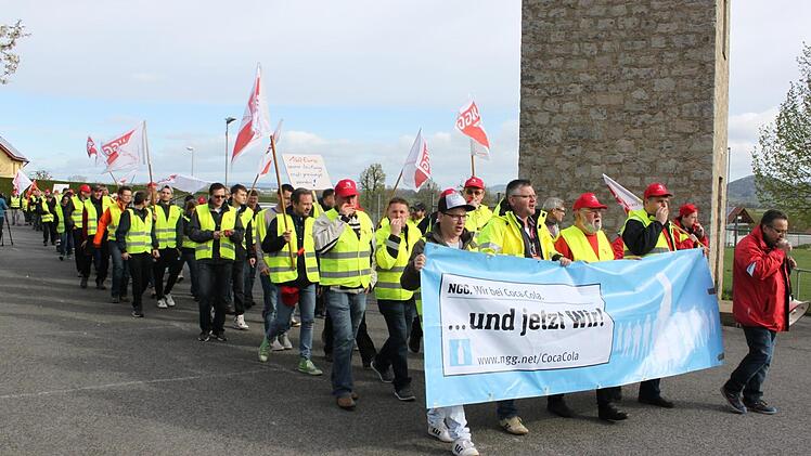Mit einem Protestzug vom Coca-Cola-Werk zum TSV-Sportheim forderten die Streikenden in Knetzgau mehr Geld. Vorneweg (in der roten Jacke) läuft Ibo Ocak, der Geschäftsführer der Gewerkschaft Nahrung, Genuss, Gaststätten. Im Vereinsheim fand dann eine Kundgebung statt, bei der die Positionen der Mitarbeiter unterstrichen wurden.  Foto: Christiane Reuther