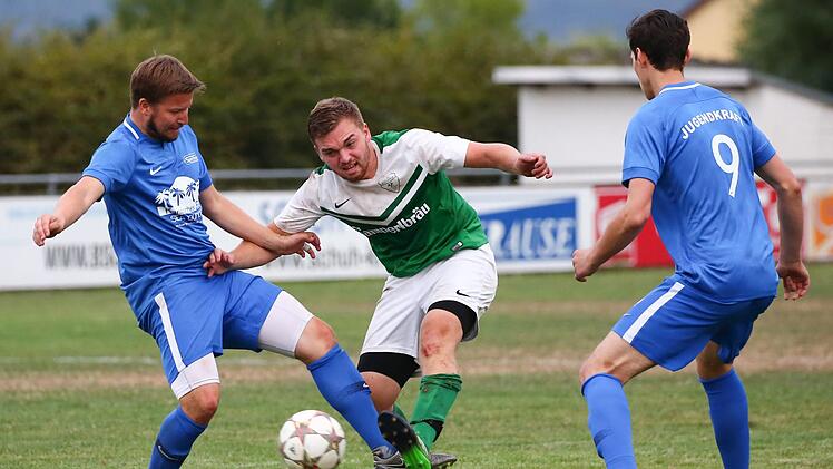 Gegen die Lichtenfelser Maurice Koch und Aleksander Hurec (blaue Trikots, v. l.) versucht Christian Wachter vom FC Stockheim, zum Torschuss zu kommen.  Foto: Heinrich Wei&szlig;
