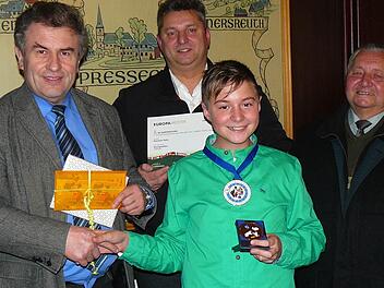 Stolz zeigt der junge Pressecker Rassekaninchenzüchter Felix Heinisch (Bildmitte) seine Medaillen als Europameister und -champion für seine Züchtungen "Zwergwidder wildfarbig". Bürgermeister Siegfried Beyer (links) beglückwünschte ihn mit einem Buchpräsent und LQN-Talern; weiter im Bild Kleintierzucht-Vereinsvorsitzender und Großvater Ferdinand sowie Vater Michael Heinisch. Foto: Klaus-Peter Wulf