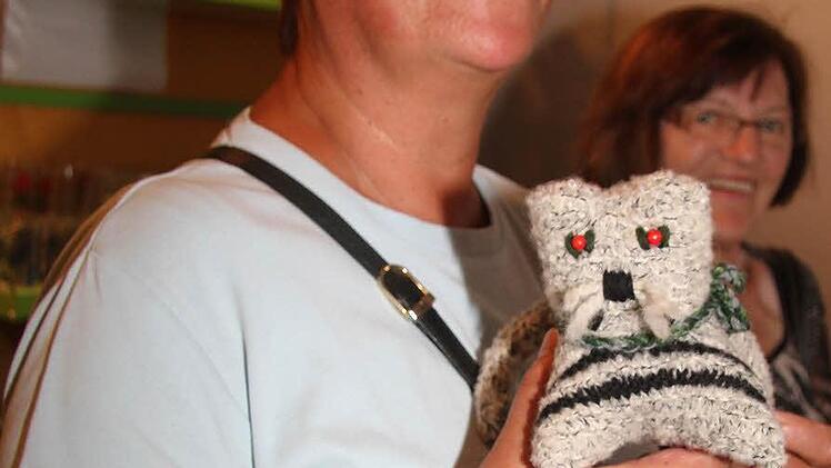 Gisela Thun ist fündig geworden. Sie greift im Flohmarktregal nach einer Häkelkatze.