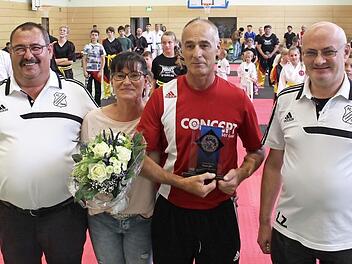 Wolfgang Gumbrecht (links) und Lothar Zürl (rechts) vom FC Pommersfelden gratulierten Rainer Giel zum Jubiläum. Gudrun Giel dankten die Vereinsfunktionäre mit einem Blumenstrauß dafür, dass sie wegen des Sports so oft auf ihren Mann verzichtet.