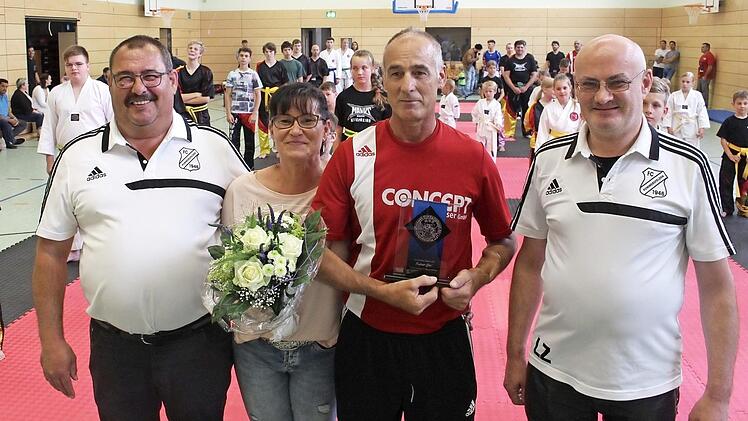 Wolfgang Gumbrecht (links) und Lothar Zürl (rechts) vom FC Pommersfelden gratulierten Rainer Giel zum Jubiläum. Gudrun Giel dankten die Vereinsfunktionäre mit einem Blumenstrauß dafür, dass sie wegen des Sports so oft auf ihren Mann verzichtet.