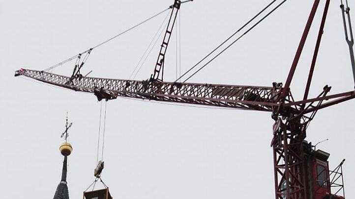 Am Haken des Auslegers: Der Kranführer fährt die beiden Dachdecker in der Arbeitsbühne zum Südturm hoch samt Arbeitsgeräten und Material. Dort haben sie gearbeitet.  Fotos: Rainer von Andrian-Werburg/Dachdecker Collins/Ruprecht