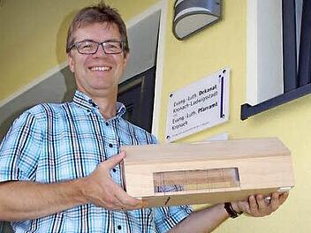 Pfarrer Martin Gundermann freut sich auf die baldige Realisierung des Gemeindehauses. Das Bild zeigt ihm mit einem Model, das Adolf Engel nach Originalmaßstab nachgebaut hat.  Foto: Heike Schülein