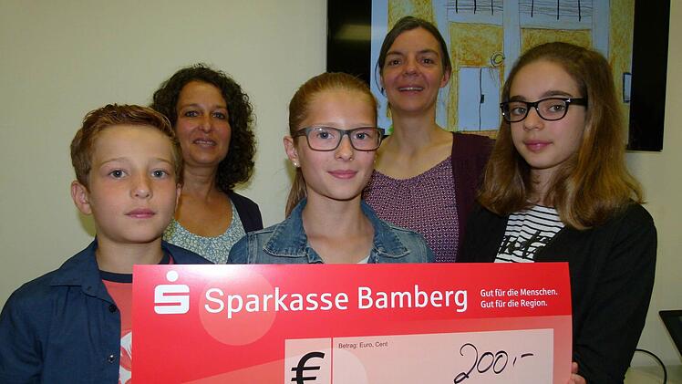 Die jüngsten Teilnehmer am Wettbewerb punkteten mit ihren Zeichnungen: v. l. Lenny, Jomina und Lindona, hinten Mutter Natalie (links) und Anja Münzel vom Caritas-Stützpunkt im "Haus Miteinander". Foto: Marion Krüger-Hundrup