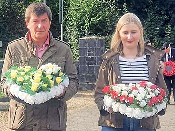 Reiner Schunder und Valerie Schullan bringen Kränze zum Friedensdenkmal.