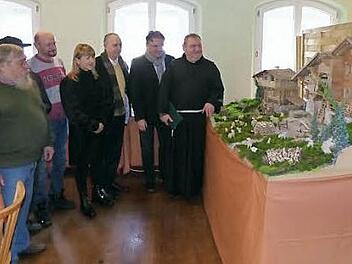 Pfarrer Pater Adrian Manderla, Landrat Klaus Peter Söllner und Bürgermeister Franz Uome (von rechts) mit einigen Ausstellern beim Betrachten der Krippe der Familie Köppel aus Stammbach. Foto: Klaus-Peter Wulf