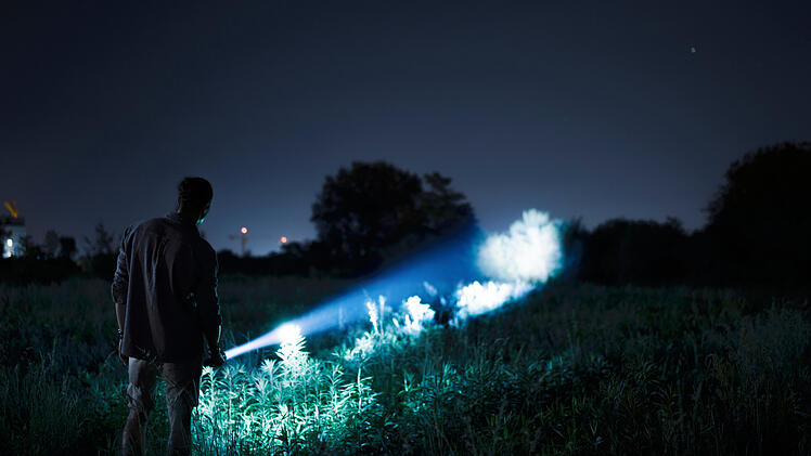 Person with flashlight at night