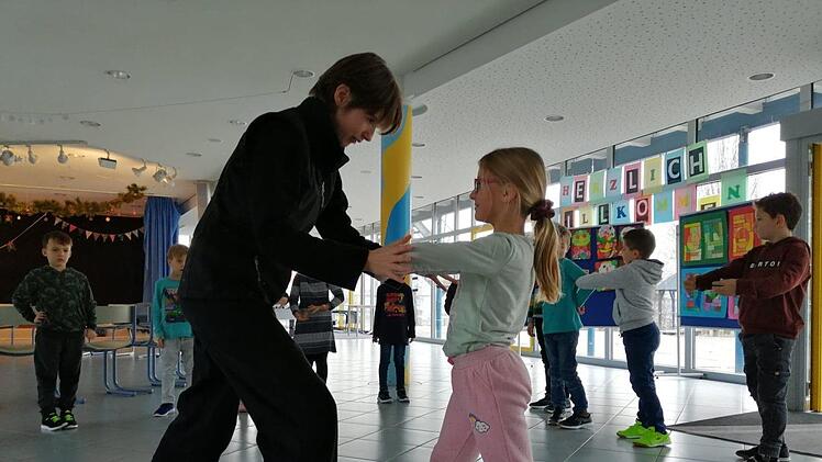 Janine Böhme zeigt den Schülern spielerisch, wie sie sich gegen Schläge oder Tritte wehren. Foto: Franziska Rieger