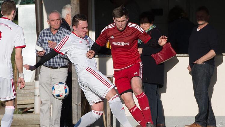 Aufmerksame Beobachter vor der Weißenbrunner Bratwurstbude: Philipp Krauß (weißes Trikot) versucht noch den Fuß an den Ball zu bringen als der Marktgraitzer Christian Bülling flanken will. Foto: Heinrich Weiß