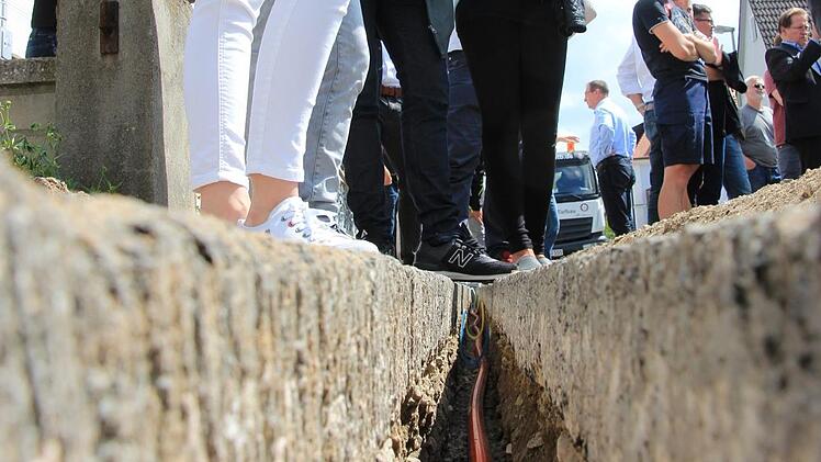 So sehen die Schlitze aus, die die Maschine in die Straße fräst. Darin liegen die roten Leerrohre, in die später die Glasfaserkabel eingeblasen werden. Foto: Tobias Kindermann