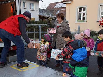Die Kälte war kein Hinderungsgrund: Die Kinder trugen die Geschenkpäckchen selbst zum Lastwagen.  Foto: Anton Then