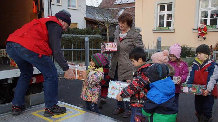 Die Kälte war kein Hinderungsgrund: Die Kinder trugen die Geschenkpäckchen selbst zum Lastwagen.  Foto: Anton Then