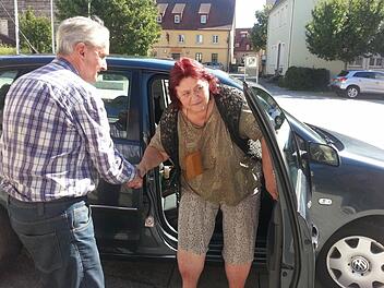 Harald Daubitz hat Waltraud Betz von zu Hause abgeholt und hilft ihr auf dem Platz vor dem Bürgerhaus beim Aussteigen. Der Hobby-Fotograf war noch in andere Hinsicht sehr aufmerksam: "Ich hab' das Auto so hingestellt, dass es passt mit dem Licht." Stimmt!   Foto: Sabine Christofzik