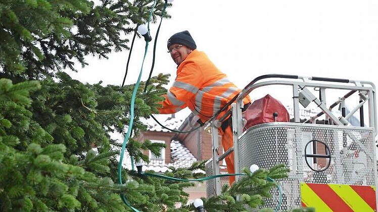 Von der Drehleiter der Feuerwehr aus bestückt Günther Franke den großen Weihnachtsbaum auf dem Marktplatz mit 200 Lämpchen für die Festbeleuchtung. Fotos: Rainer Lutz