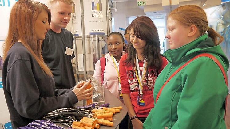 Was man bei der Firma Koch alles mit Kunststoff und einer großen Portion Kreativität machen kann, zeigen die beiden Auszubildenden Julia (links) und Tony (Zweiter von links) bei der Berufsfindungsmesse im Coburger Kongresshaus. Interessierte Schüler wie (von rechts) Melanie, Sidi und Abigail finden sich da natürlich schnell. Foto: Berthold Köhler