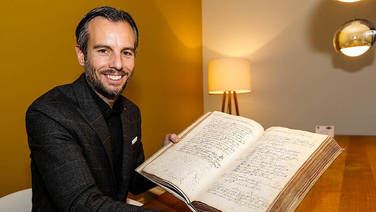 Johannes Schulz-Hess, der das Unternehmen in zehnter Generation führt, präsentiert das Zunftbuch der Bamberger Kupferschmiede aus dem Jahr 1679.
