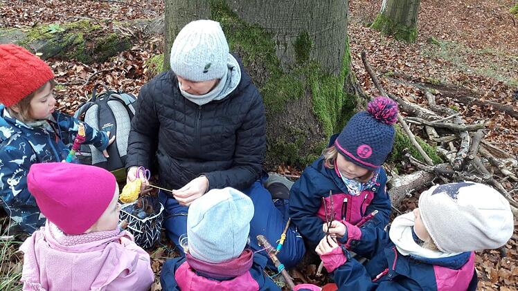 Der Ramsthaler Waldkindergarten "Weinbergschneckle" ist sehr beliebt, hat sogar schon eine Warteliste, auf die Eltern ihre Kinder bereits gleich nach der Geburt setzen lassen. Hier spielen Kinder am Fuß einer Buche mit Wollfäden und Ästen.