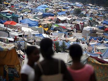 Frauen schauen in Port-au-Prince auf ein Lager, in dem 2010 &Uuml;berlebende des Bebens versorgt wurden. Oxfam-Mitarbeiter sollen sich w&auml;hrend ihres Hilfseinsatzes Prostituierte haben bezahlen lassen.  David Fernandez, dpa