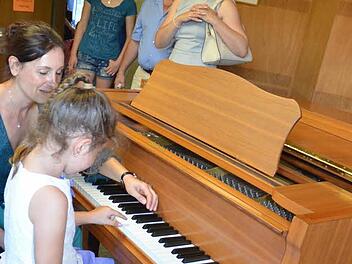 Großes Interesse bestand am Klavier. Hier darf die sechsjährige Katharina Beetz erste Töne auf der Tastatur spielen, geführt von Musiklehrerin Yvonne Preising. Entlang der "Klangstraße" durften alle Instrumente ausprobiert werden. Foto: Karl-Heinz Hofmann