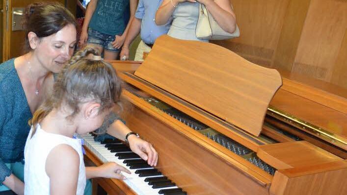 Großes Interesse bestand am Klavier. Hier darf die sechsjährige Katharina Beetz erste Töne auf der Tastatur spielen, geführt von Musiklehrerin Yvonne Preising. Entlang der "Klangstraße" durften alle Instrumente ausprobiert werden. Foto: Karl-Heinz Hofmann
