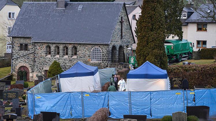 Polizeibeamte suchen auf dem Friedhof in Lichtenberg unter Zelten im Grab einer 81-Jährigen Frau nach der Leiche des Mädchens Peggy. Foto: David Ebener/dpa