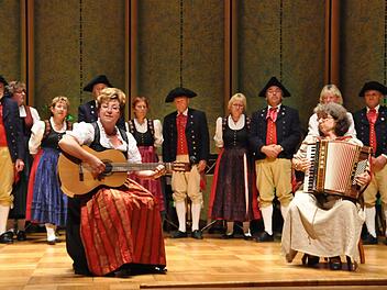 Ein farbenfrohes Bild auf der Bühne mit Gabi Kanz (links), Lissy Heilgenthal (rechts) und der Volkstanzgruppe Fuchsstadt im Hintergrund. Fotos: Klopf