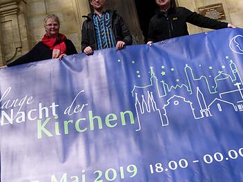 Andrea Hofmann, Jochen Högendörfer und Ulrich Ortner (v.l.) präsentieren vor der St. Jakobskirche das Banner zur "Langen Nacht der Kirchen".   Fotos: Marion Krüger-Hundrup