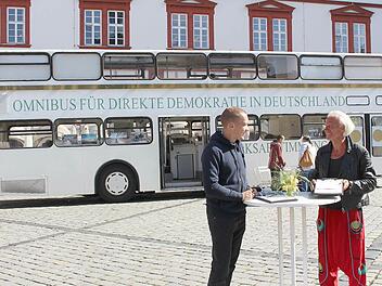Werner Küppers (rechts) und Christopher Pinnekamp informieren mit zwei weiteren Kollegen über die Initiative, die Volksabstimmungen auch auf Bundesebene einzuführen. Am Freitag, 12. August, steht der Omnibus noch von 9.30 bis 18 Uhr auf dem Coburger Marktplatz. Foto: Ulrike Nauer