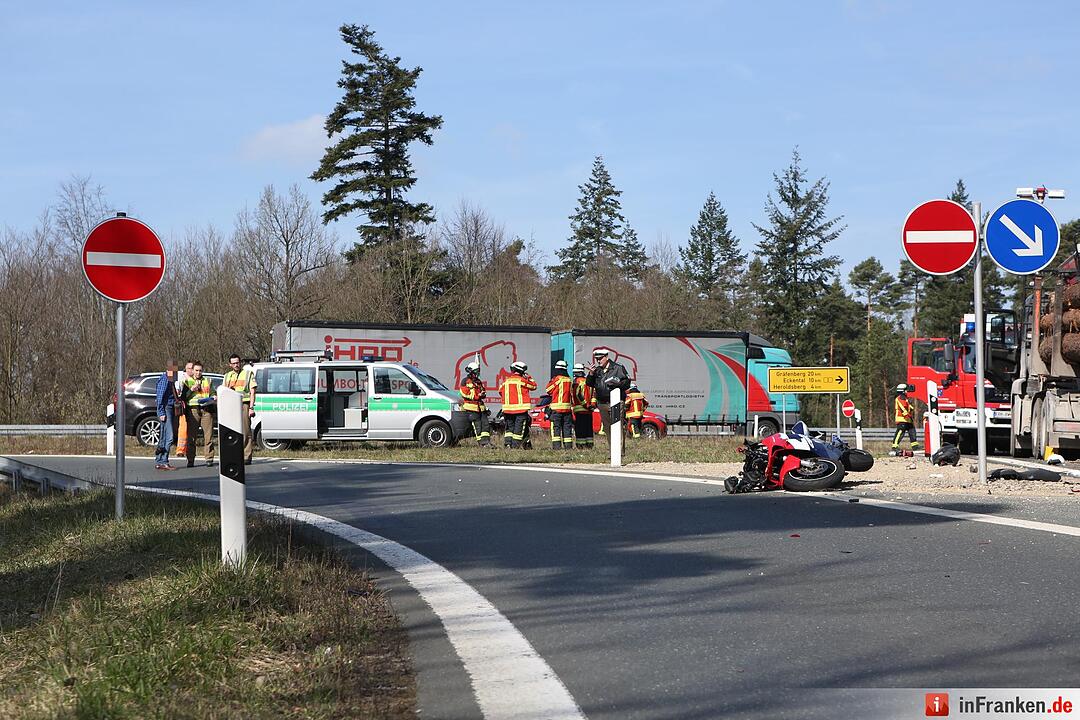 Motorradfahrer rutscht unter Lastwagen