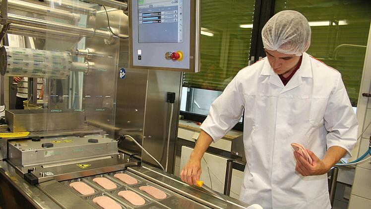 Simon B&uuml;hler ist seit einem Jahr an der Staatlichen Fachschule f&uuml;r Lebensmitteltechnik. Er stand beim Tag der offenen T&uuml;r an der automatischen Wurstschneide- und Verpackungsmaschine. Wurst wird kurz angefroren, ehe sie in Scheiben geschnitten wird. Foto: Sonny Adam